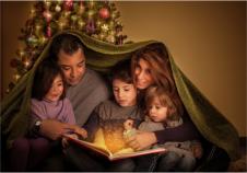 Familie am Vorlesen - Mamma, Papa und drei Kinder